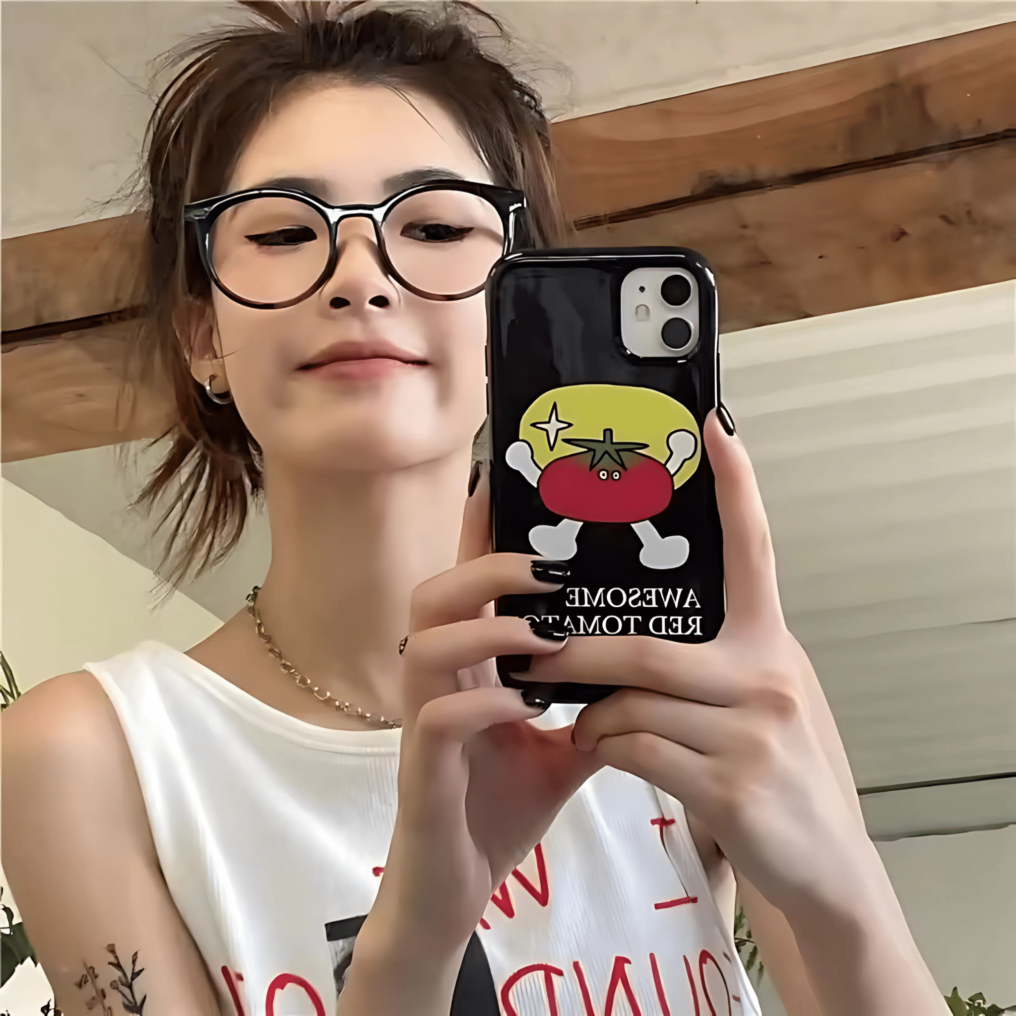 Person holding a phone with a cartoon tomato design