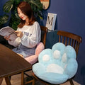 Woman reading a magazine on a chair with a paw-shaped cushion