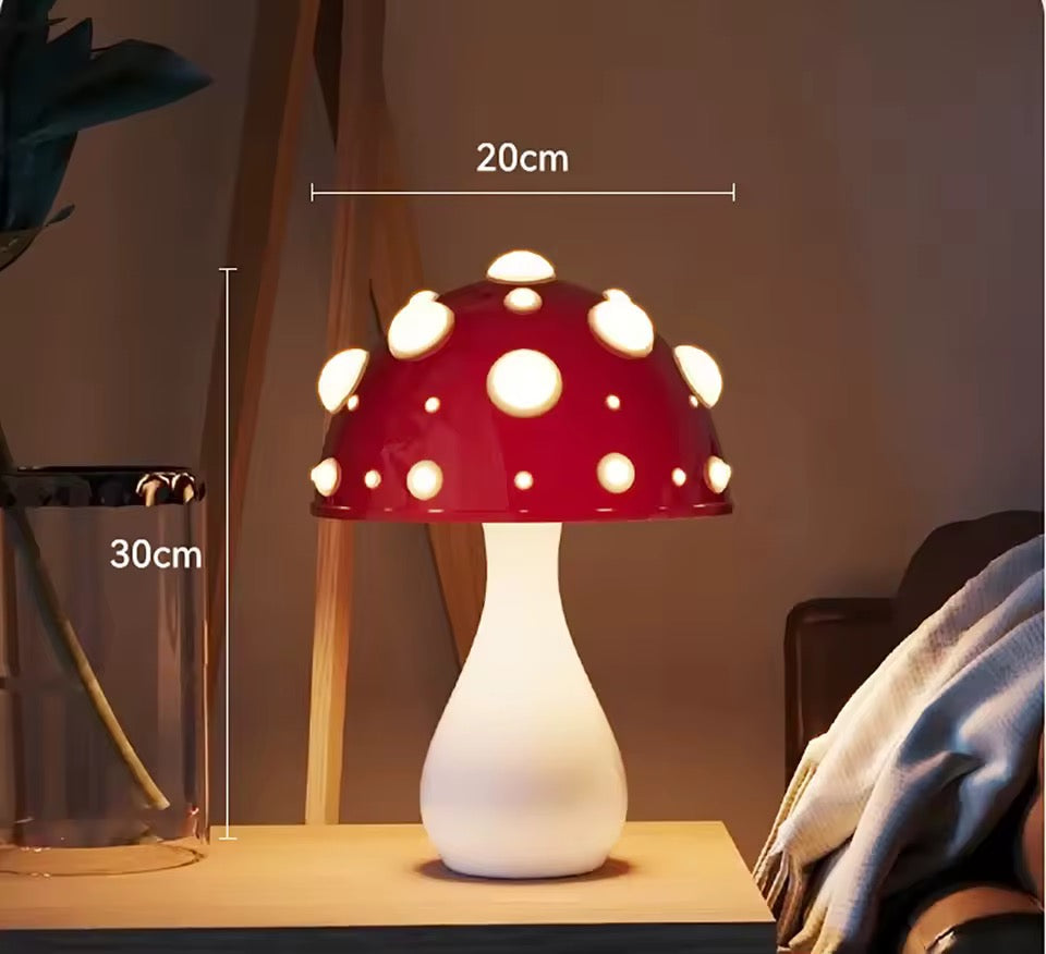 Mushroom-shaped lamp with red cap and white stem in a garden setting with flowers.