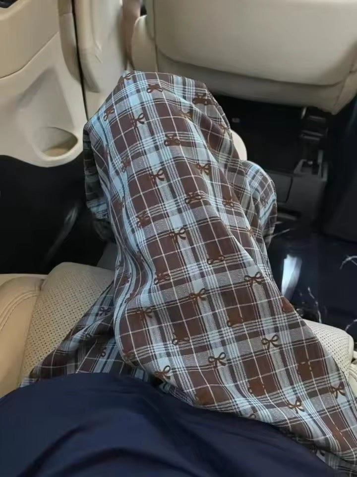 Plaid pants with brown and blue pattern inside a vehicle.