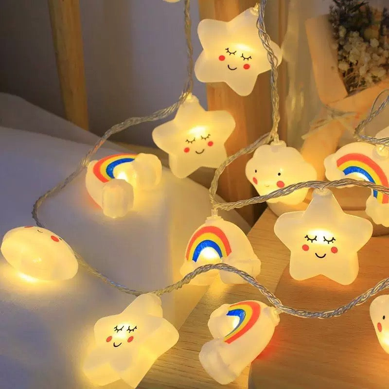 String lights shaped like stars with rainbow designs on a wooden surface.