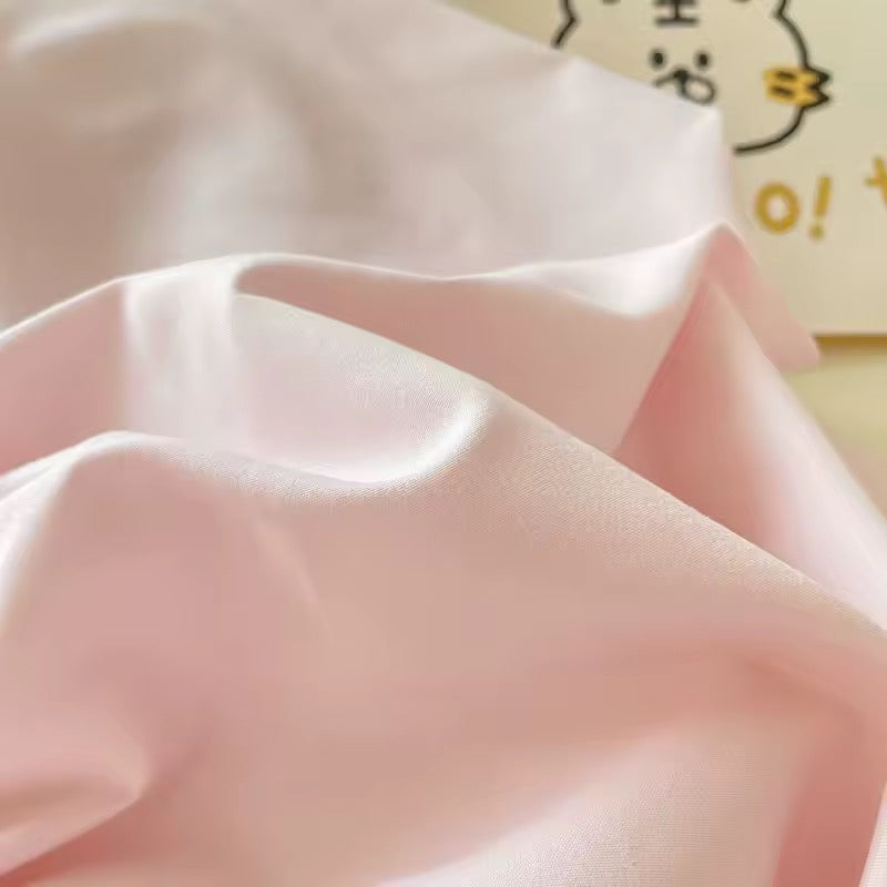 Aesthetic college bedding set in pastel pink and cream, styled with cozy accessories.