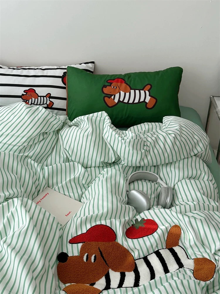 Children's bed with green striped bedding and cartoon dog design, featuring a green pillow with a cartoon zebra.