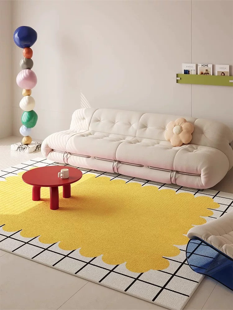 Modern living room with a pink rug, white sofa, and colorful decor elements.
