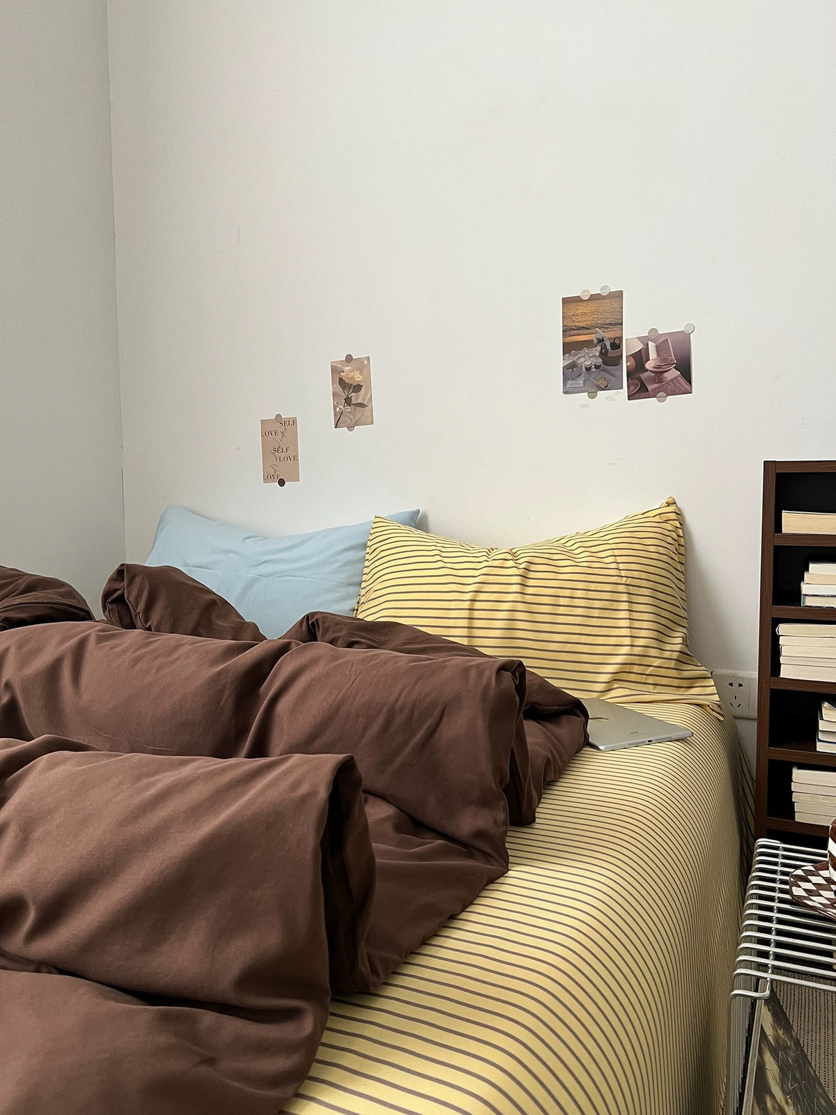 Side view of dark brown bedding set with striped sheet and mixed pillows