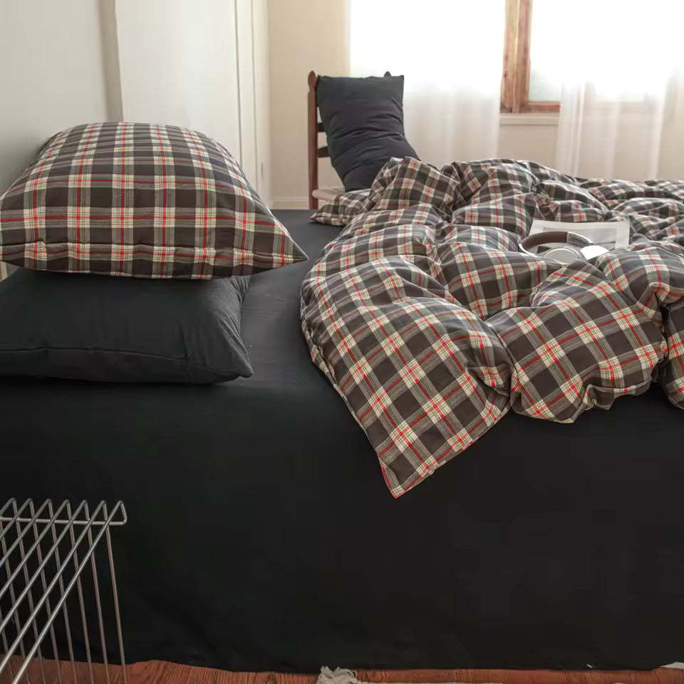 Bed with plaid comforter and pillows in a bedroom setting