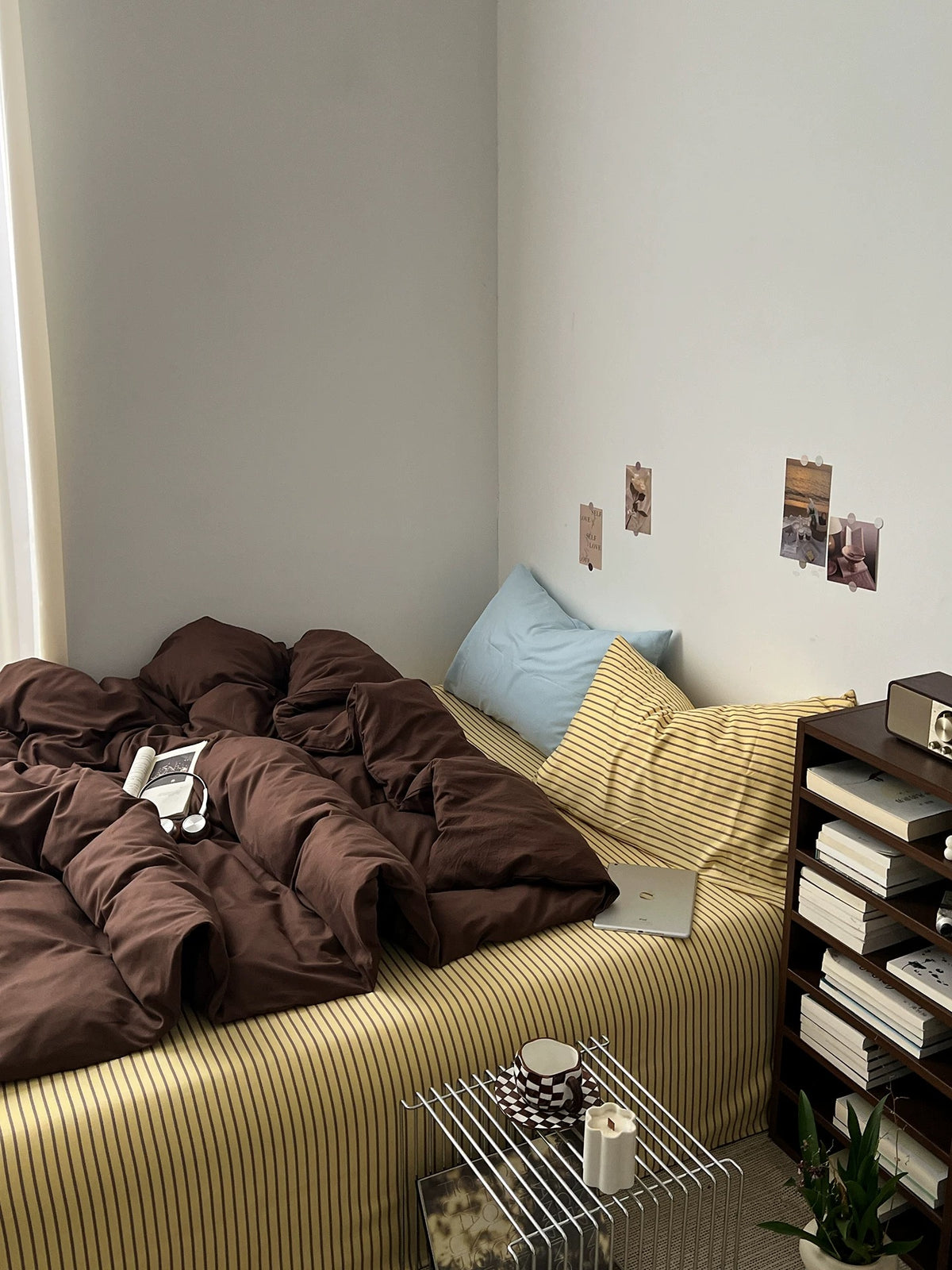 Dark brown duvet cover on a bed with pale blue and striped pillows