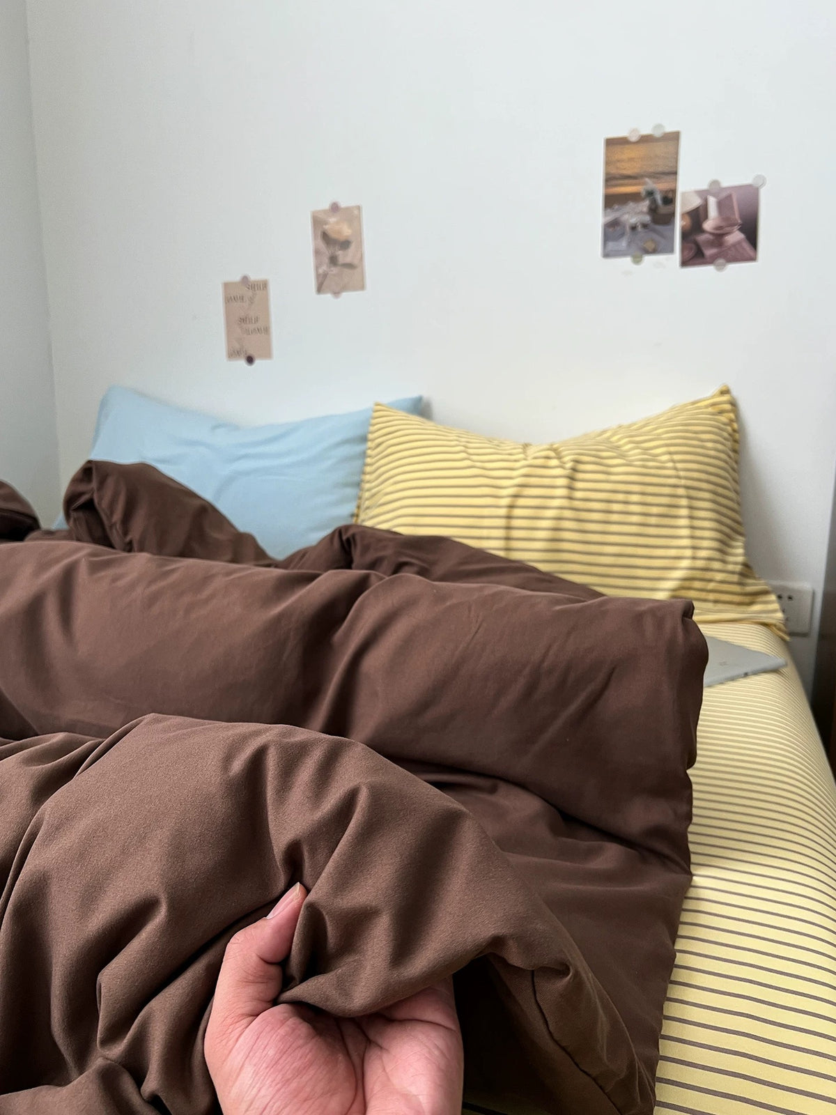 Dark brown duvet cover layered over a fine striped sheet