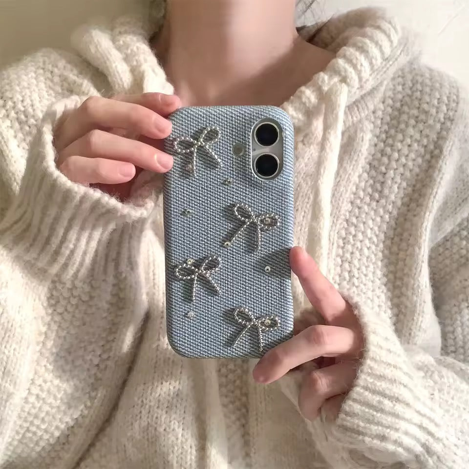 Person holding a phone case with bow designs against a neutral background