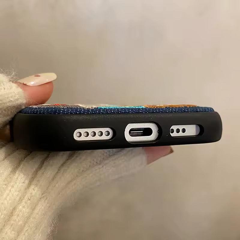 Phone case with ports and textures held by a hand against a neutral background