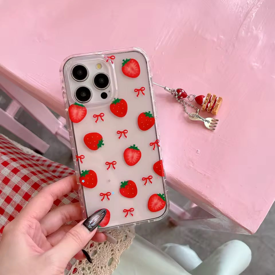 Phone case with strawberry pattern held by a hand on a pink surface