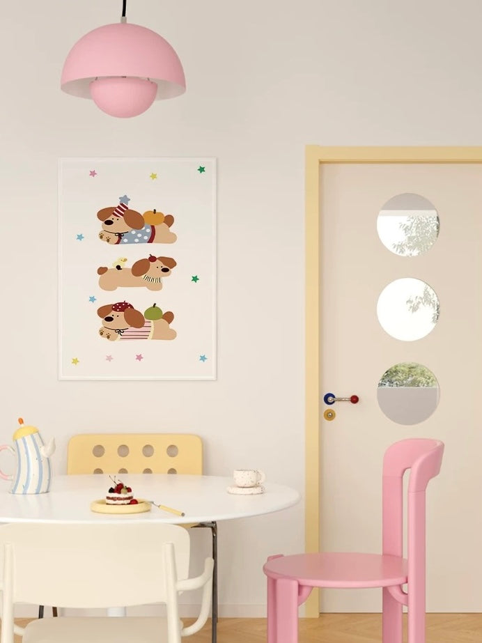 A dog tapestry with three puppy illustrations and scattered colored stars hangs above a table beside a pink chair.