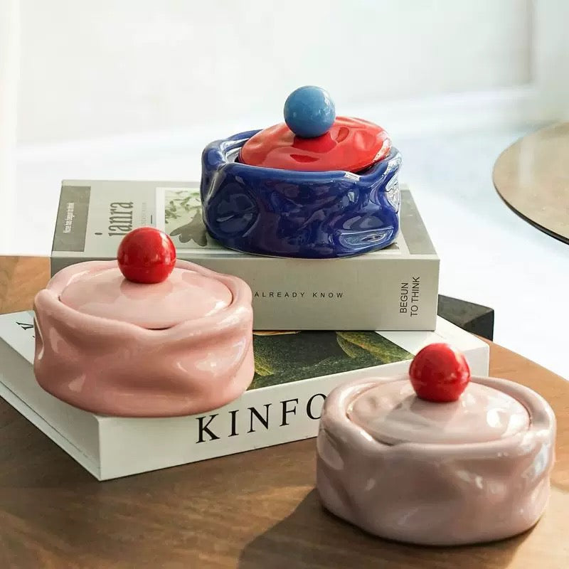 Colorful ceramic containers with lids on a wooden surface