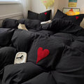 Emo coquette bedroom featuring black heart bedding and a pastel accent wall