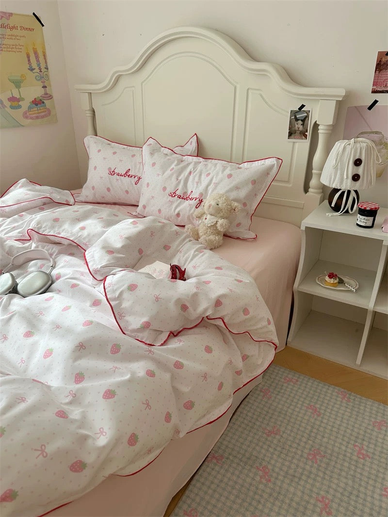 Children's bedroom with pink and white bedding, teddy bear, and nightstand.