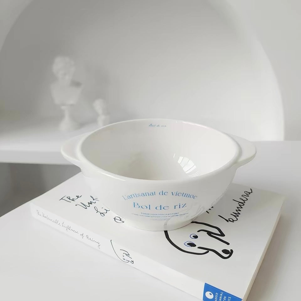 White ceramic bowl with side handles blue French text and measurements displayed beside the piece