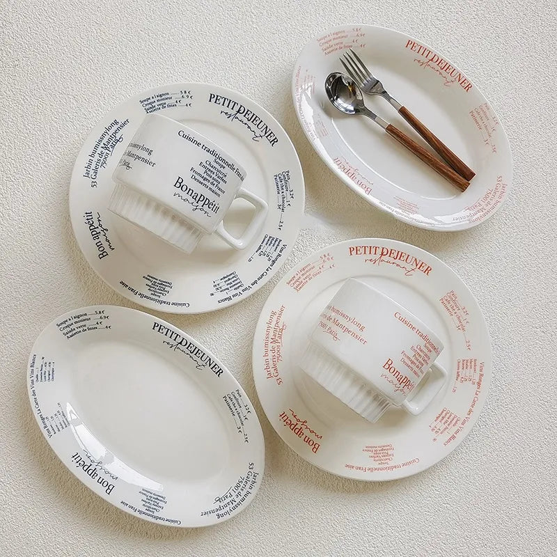 White pottery mug with blue French menu lettering and square handle shown against plain background