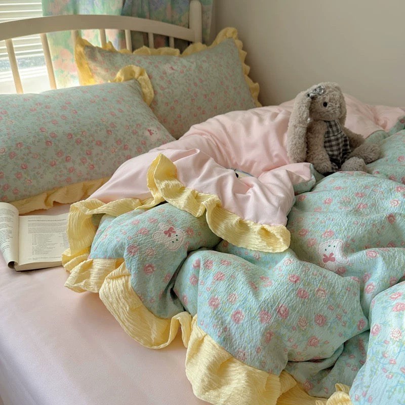 Cottagecore bedroom setup with floral ruffle bedding, plush bunny, and a bowl of fruit
