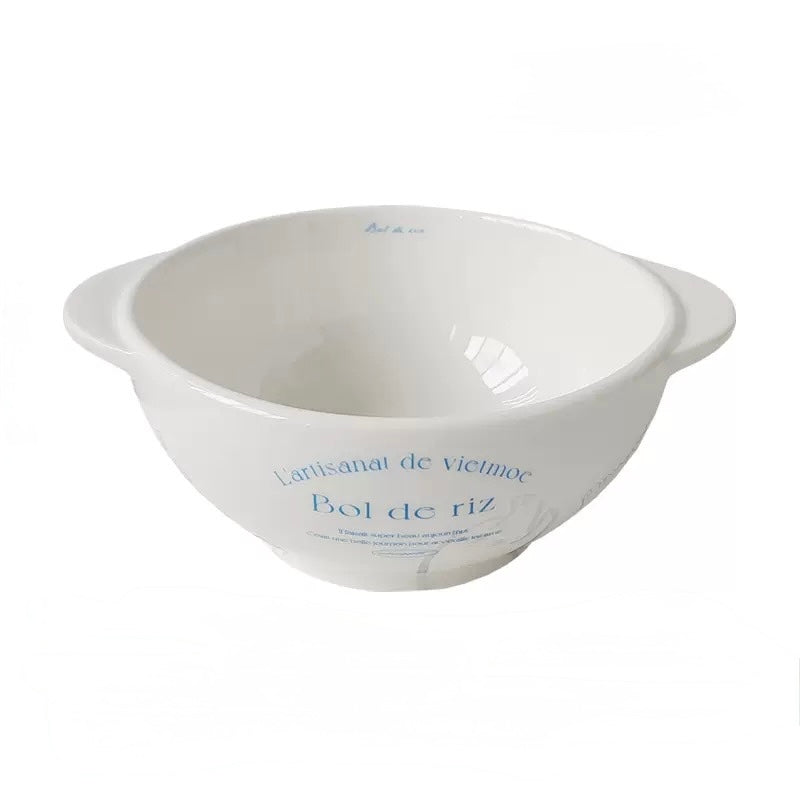 Round white pottery dinner plate with blue lettering and simple French bistro inspired graphic details