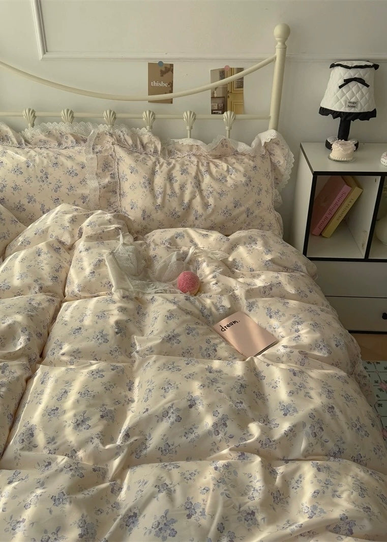 Floral patterned comforter on a bed with a nightstand in the background