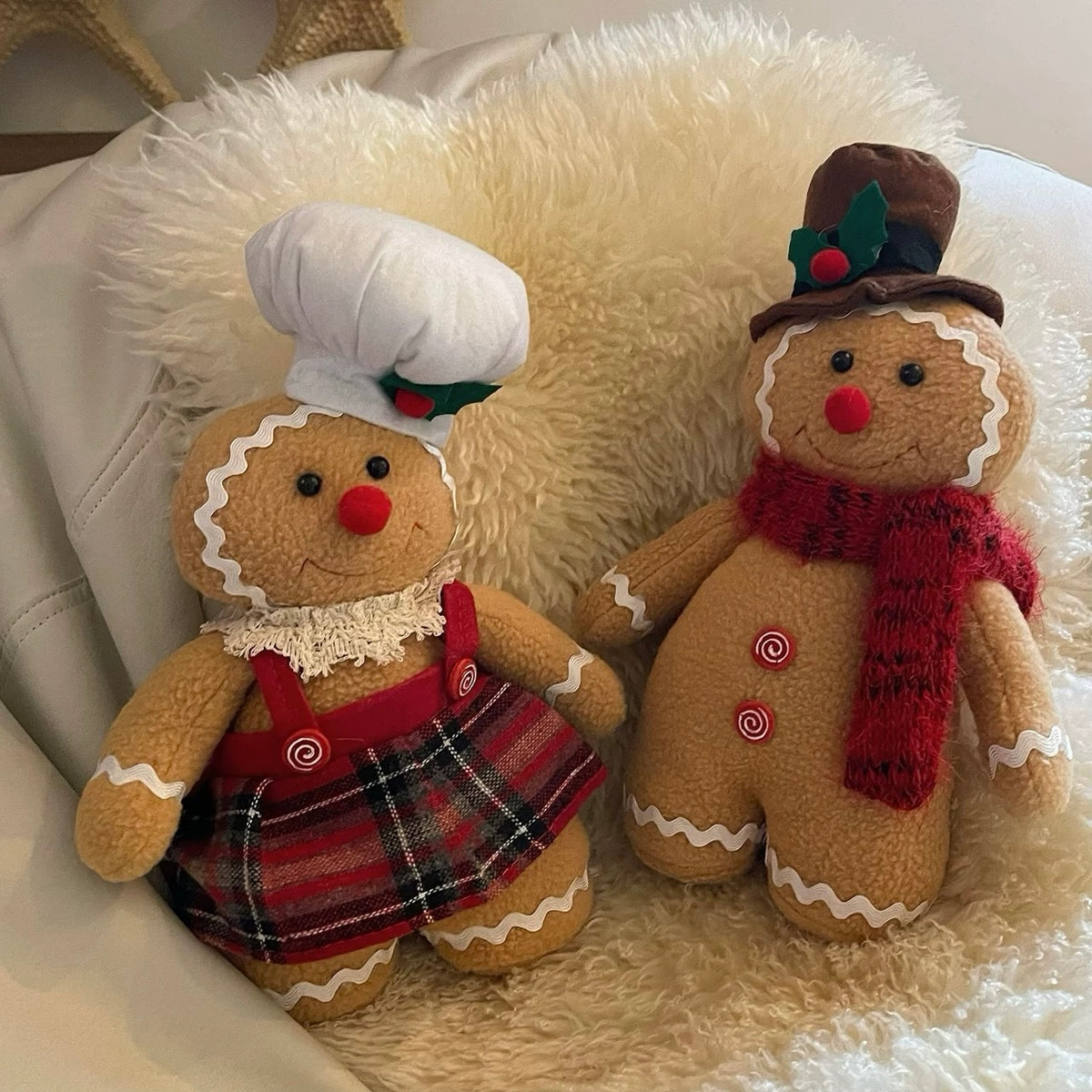 Gingerbread decorations show the man in a red scarf beside the woman in a plaid skirt on a chair.