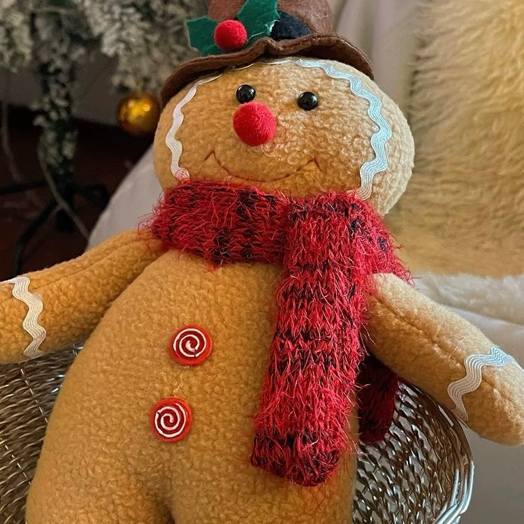 The gingerbread man doll wears a brown top hat with holly leaves, a red scarf and red spiral buttons.