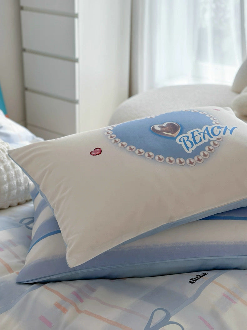 Decorative pillow with 'BEAC' text on a bed with colorful bedding