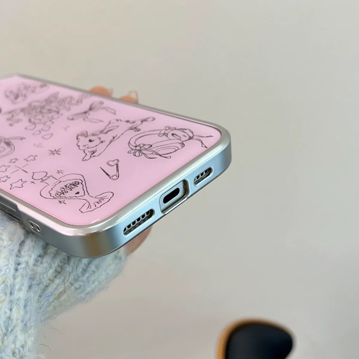 Phone case with cartoon designs on a pink background