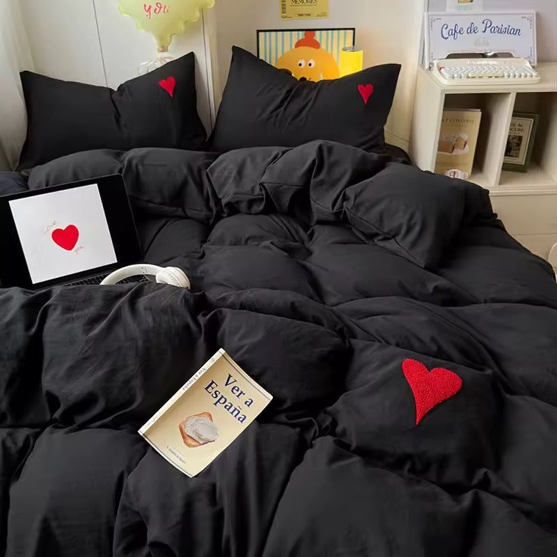 4-piece cotton bedding set featuring black duvet, sheet, and heart pillows