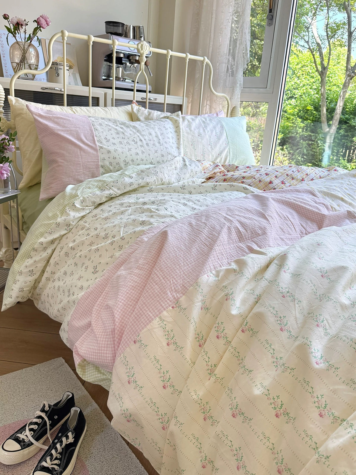 Green floral duvet cover with pink gingham patchwork on a sunlit bed