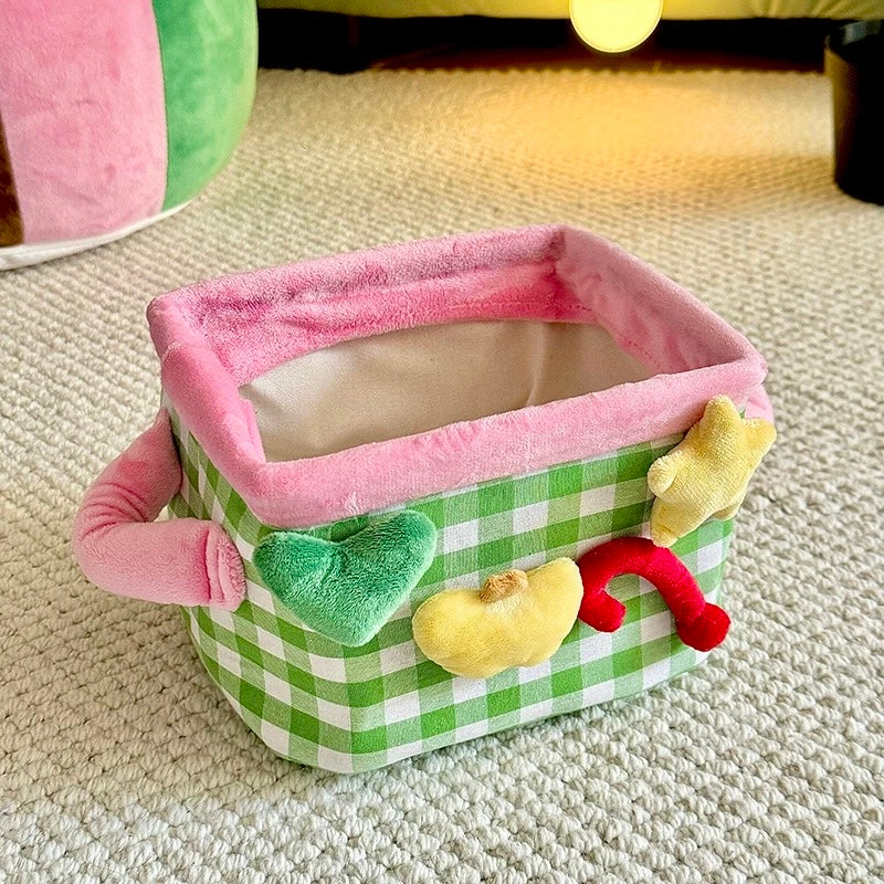 Green plaid storage basket open with pink rim and colorful decorative shapes