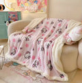 Hello Kitty plush blanket styled on pastel bedding with soft pillows