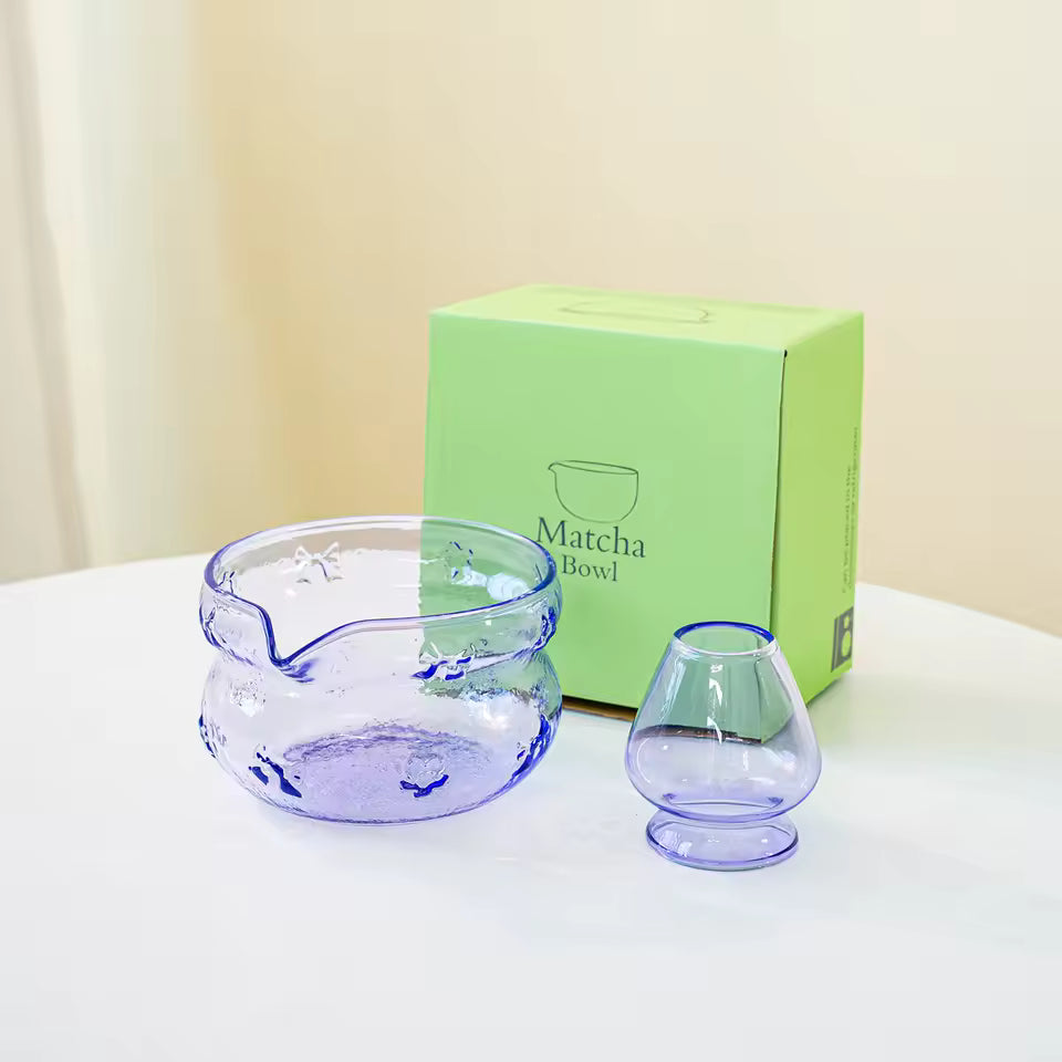 Clear glass matcha bowl and small cup with a green box labeled 'Matcha Bowl' on a white surface.