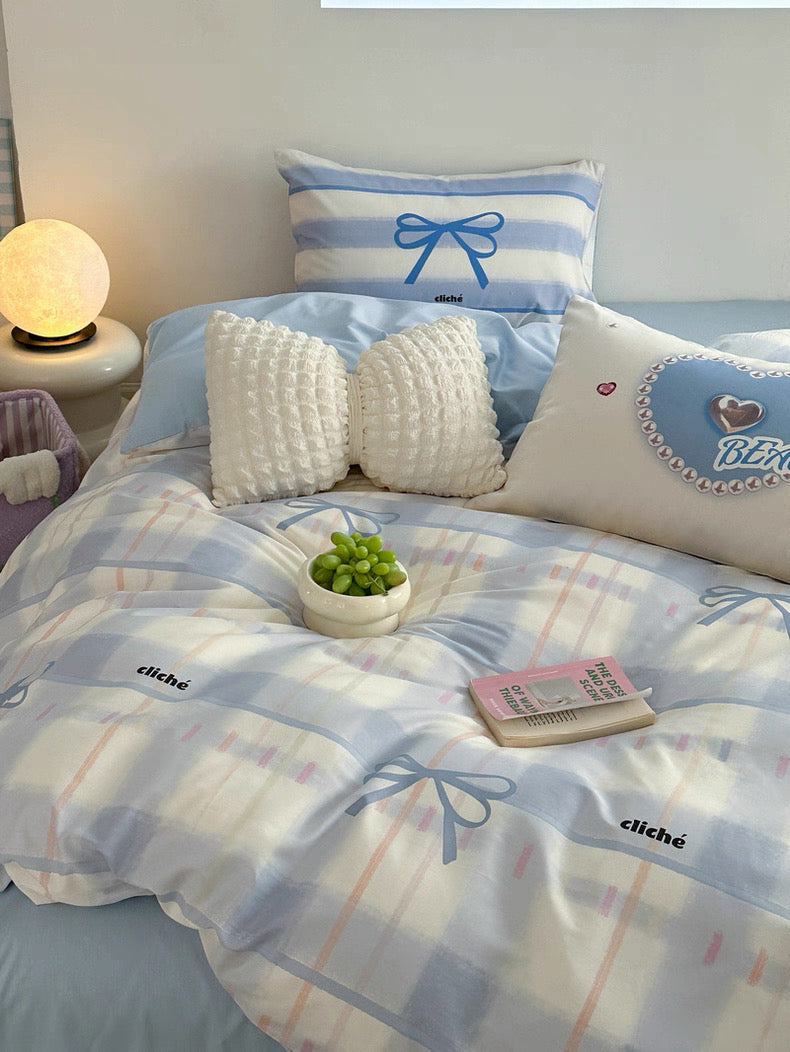 Bed with checkered bedding and decorative pillows in a bedroom setting.