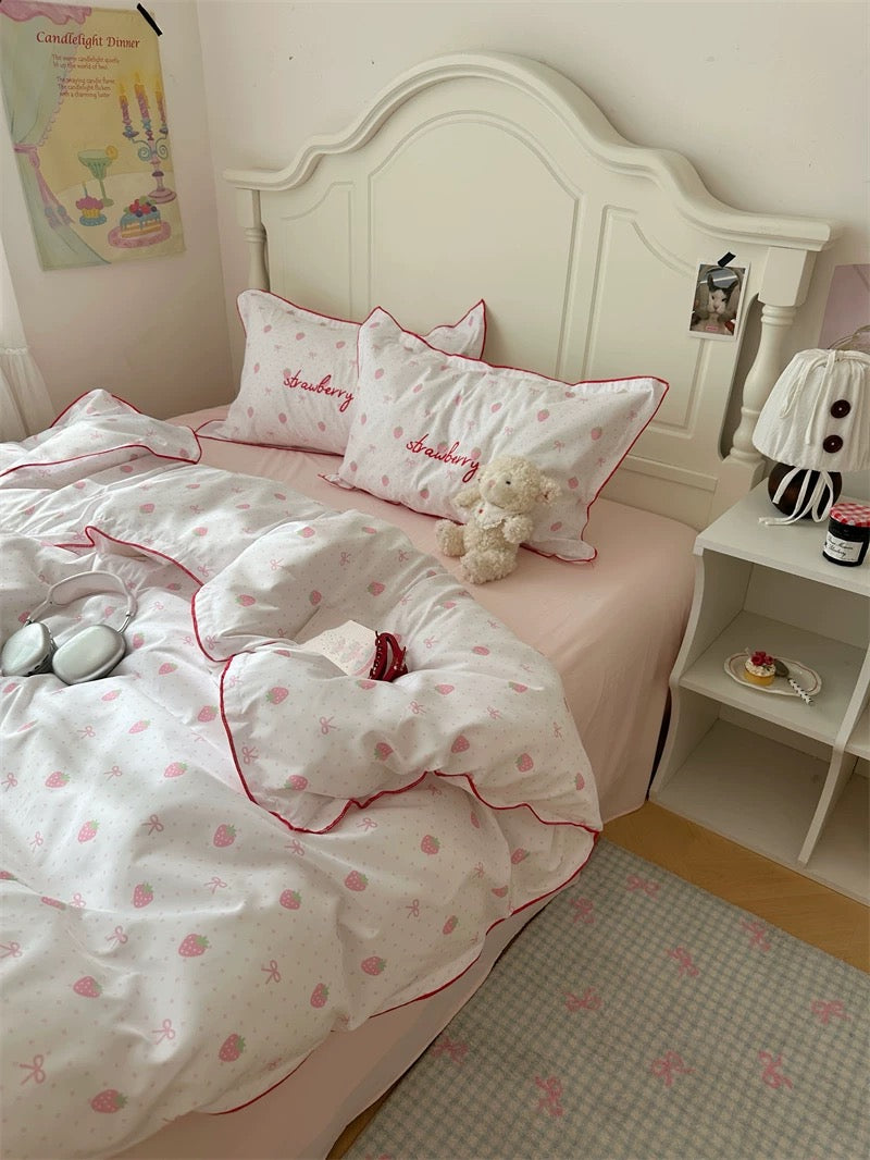 Bedroom with a bed featuring pink and white bedding, a teddy bear, and a nightstand.