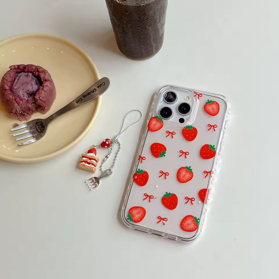 Phone case with strawberry pattern next to a dessert and drink on a white surface