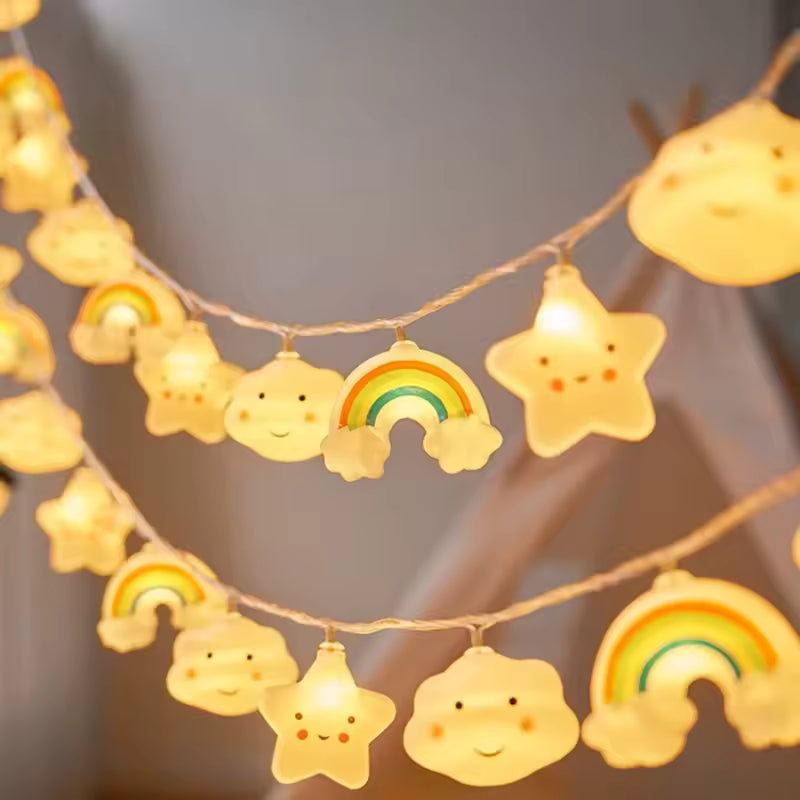 String lights with cloud and rainbow designs on a blurred background