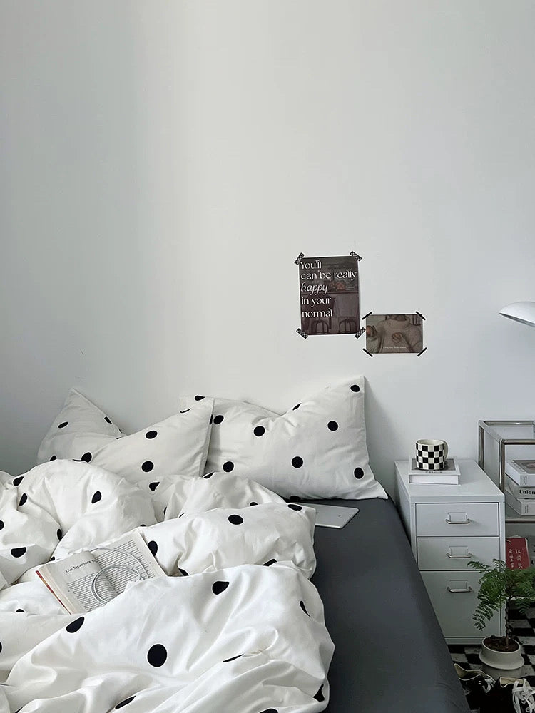 Bedroom with polka dot bedding and decorative wall signs.