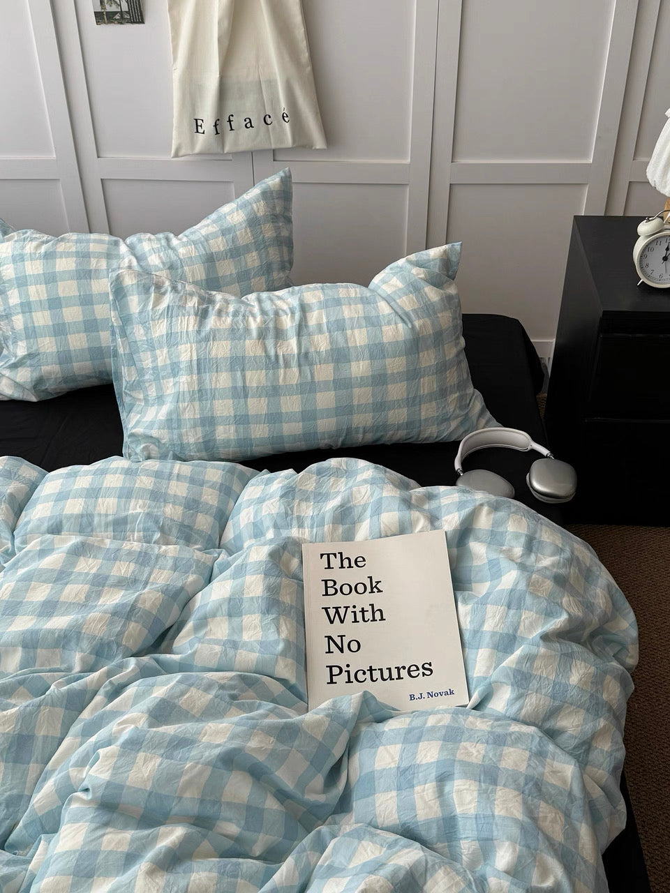 Light blue gingham bedding styled with solid black pillows and matching checked pillowcases
