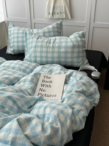 Light blue gingham duvet cover with black pillows on a styled preppy bed