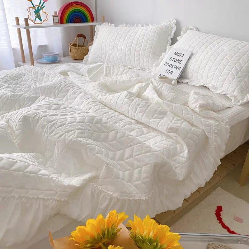 Lightweight quilted blanket with soft ruffle trim for bedroom styling