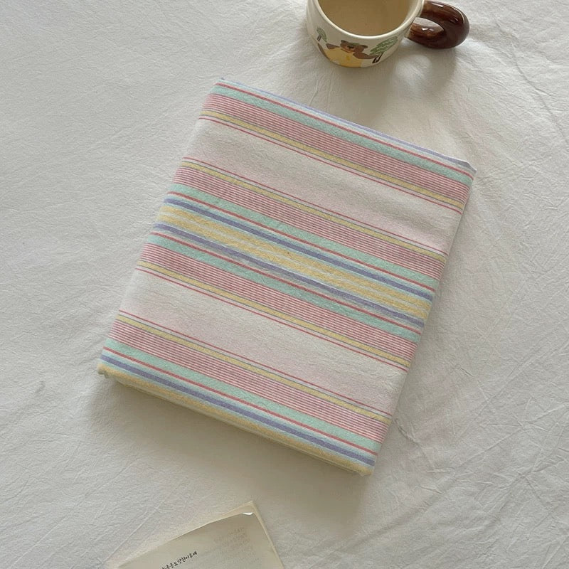 Striped notebook with a mug on a textured white surface