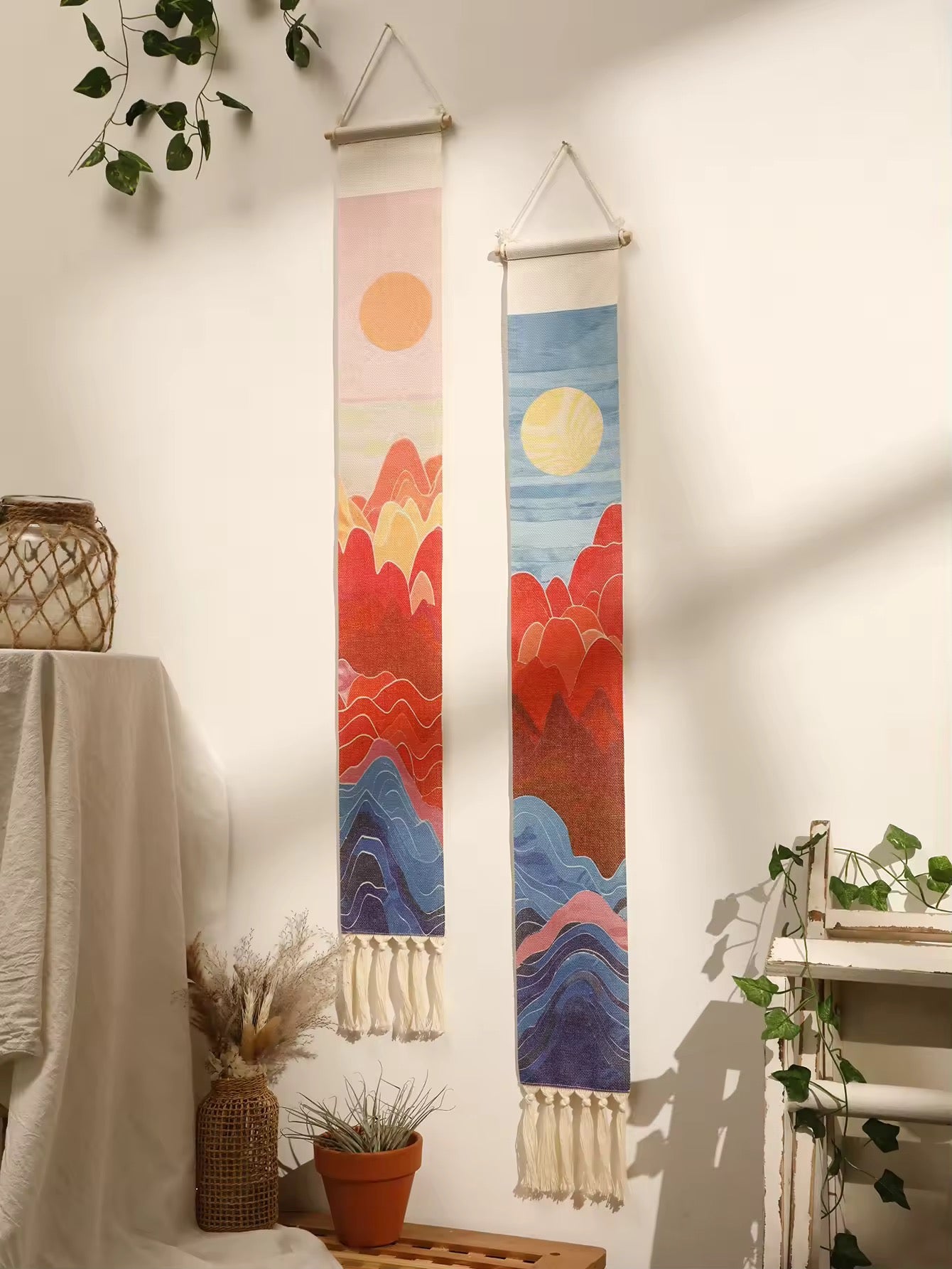 Vertical fringe tapestry styled above a bed in neutral-toned room