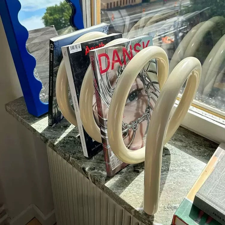 Magazine holder with books on a windowsill