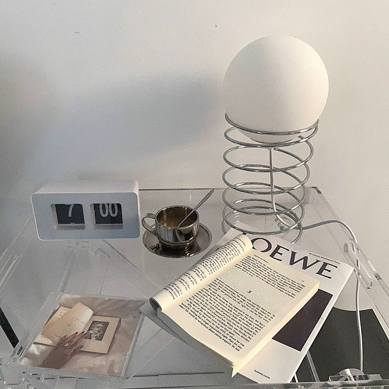 Aesthetic arrangement featuring the lamp with books and decor items