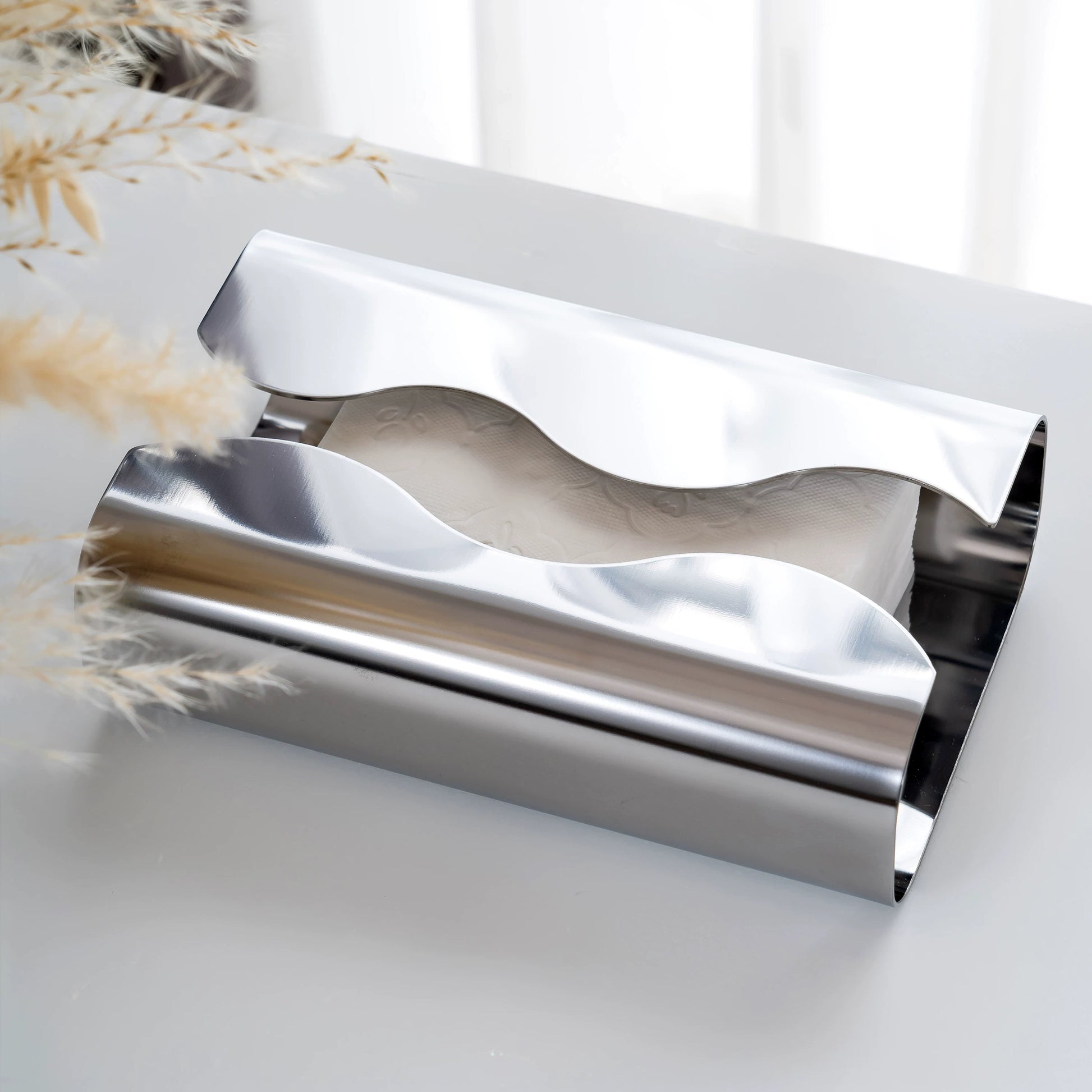Metallic tissue holder on a marble surface with a blurred background