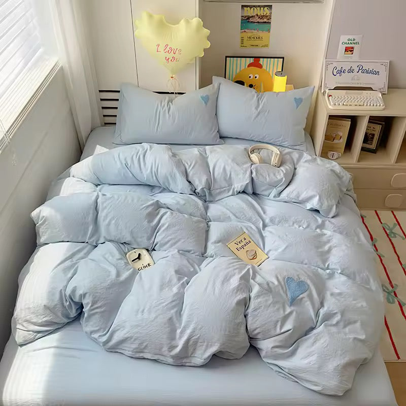 Coquette bedroom setup with heart bedding and soft lighting.