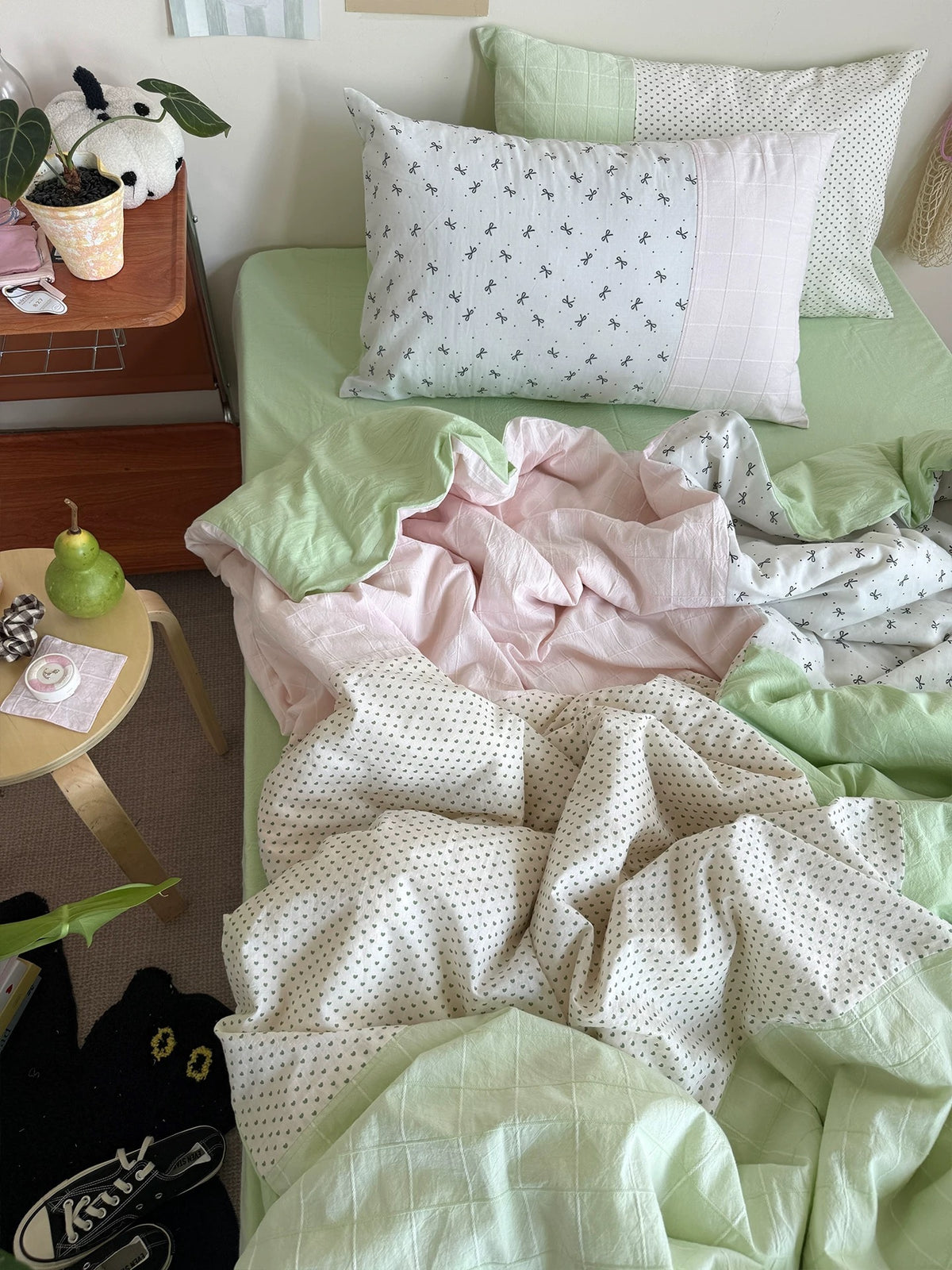 Pastel patchwork bedding set photographed from the foot of the bed