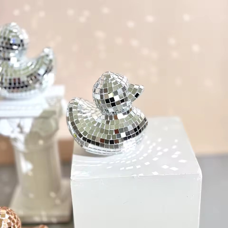Decorative duck with mosaic finish on a white base against a blurred background