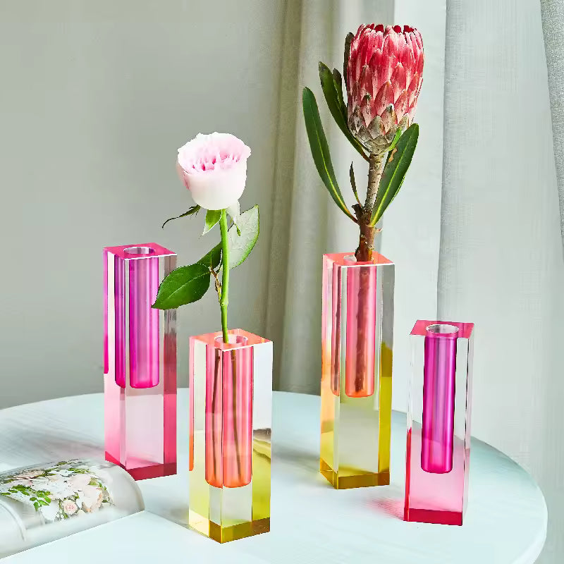Set of four gradient vases with flowers on a light surface